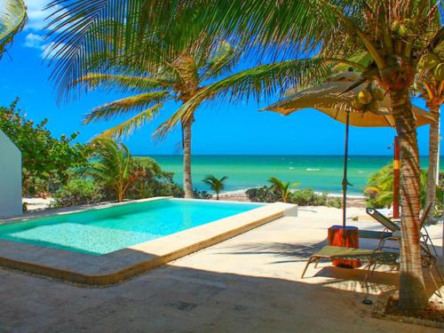 - une piscine à côté d'une plage avec un palmier dans l'établissement Hidra luxurious accommodation, à San Benito