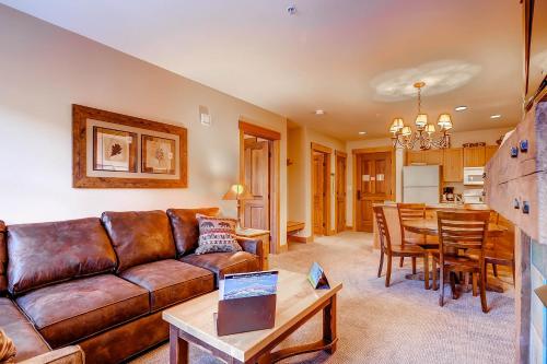 a living room with a brown leather couch and a table at The Springs Condominiums by Vail Resorts in Keystone