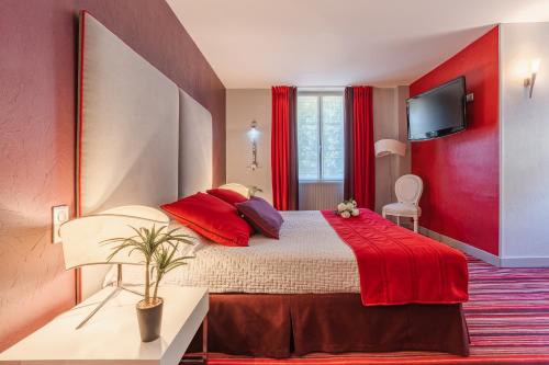 a bedroom with a large bed with red walls at Hostellerie du Passeur - Hôtel & Restaurant - Climatisation et Piscine chauffée in Les Eyzies-de-Tayac