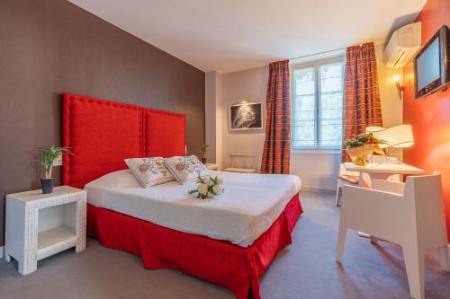 Hostellerie du Passeur - Hôtel & Restaurant - Climatisation et Piscine chauffée في ليه إيزي-دو-تاياك: غرفة نوم بسرير كبير مع اللوح الأمامي الأحمر