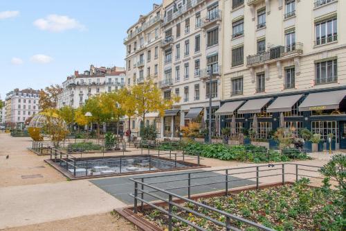 a city street with buildings and a courtyard with a fountain at Appartement Anatha - Welkeys in Lyon