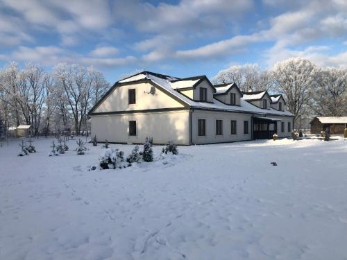 a large white building with snow on the ground at Kantonia in Bobolice