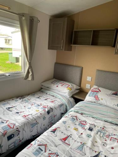 two beds sitting next to each other in a bedroom at ParkDean Cherry tree holiday park Burgh castle in Belton