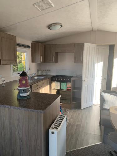 a kitchen with a counter top in a room at ParkDean Cherry tree holiday park Burgh castle in Belton
