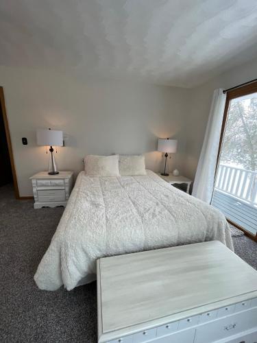 a bedroom with a white bed and a window at Breezeway Bay - Waterfront Full House in Wisconsin Dells
