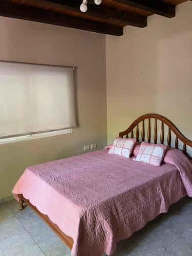 1 dormitorio con 1 cama con manta morada en Departamento Especial en Godoy Cruz