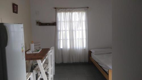 um quarto com uma cama, uma secretária e uma janela em Boa Vida em Gualeguaychú