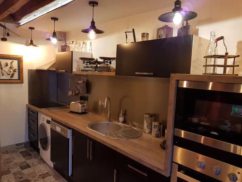 uma cozinha com um lavatório e uma máquina de lavar roupa em LOFT Parisien em Paris