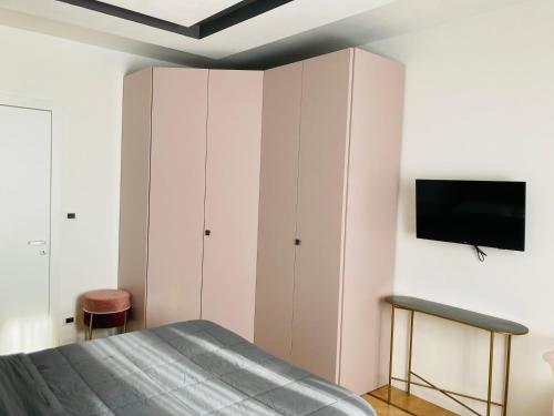 1 dormitorio con 1 cama y TV en la pared en BILOCALE_TORINO_DELUXE, en Turín