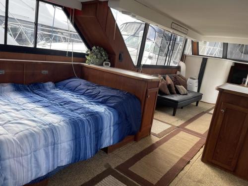 a bedroom on a boat with a bed and a couch at 50ft Stationary House Boat 