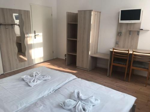 Un dormitorio con una cama blanca con toallas. en Kölner Pension, en Colonia