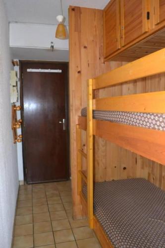 - une chambre avec des lits superposés en bois et une porte dans l'établissement studio 4 couchages, pied des pistes, à Risoul
