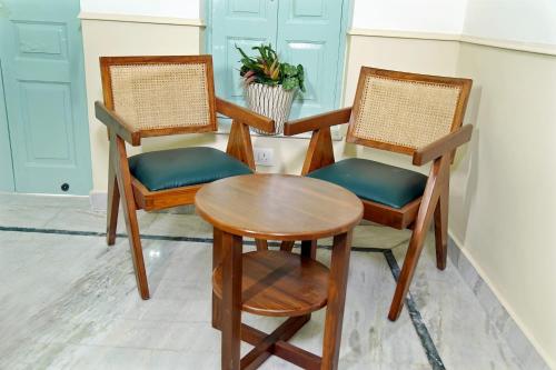 two chairs and a table in a room at Shree Krishna Bhakti Ashram in Vrindāvan