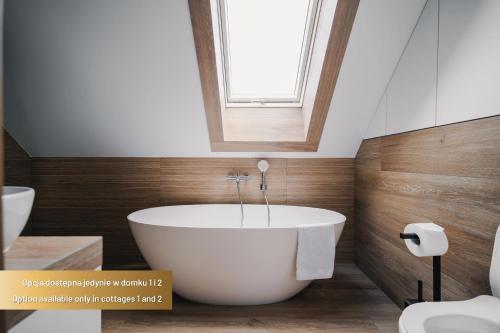 a bath tub in a bathroom with a window at Dolina Barw - całoroczne domki na wynajem in Rabka-Zdrój