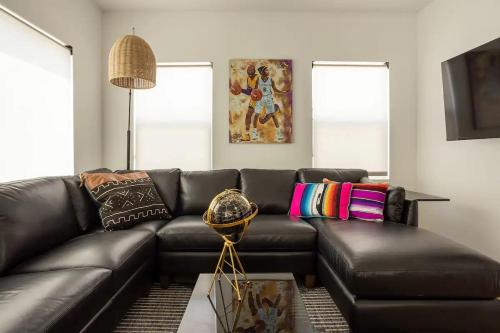 a living room with a black leather couch at Coziest 1BD Bungalow 8min from airport, 4 min SoFi in Los Angeles
