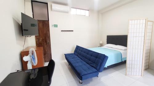 a bedroom with a blue chair and a television at Loft Central en Lamas in Lamas