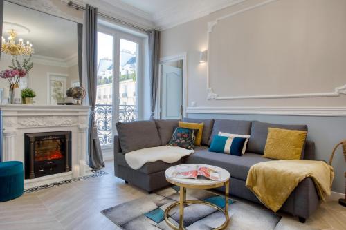 a living room with a couch and a fireplace at Marais Appart Haussmannien Neuf Clim & Ascenseur in Paris