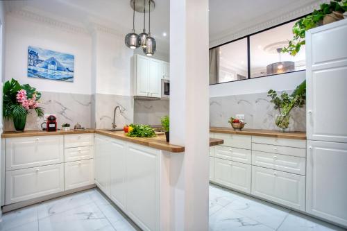 une cuisine avec des armoires blanches et une fenêtre dans l'établissement Charmant 100m2 avec 3CH - Romantique Centre Ville, à Paris