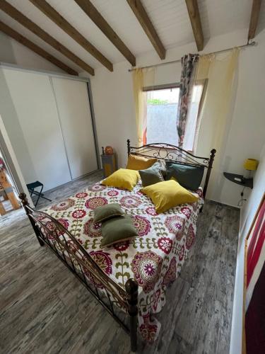 um quarto com uma cama com almofadas em Bienvenue chez Angie em Les Abymes