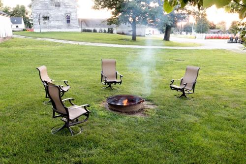 tres sillas alrededor de una hoguera en un patio en Summer Getaway with BBQ Grill, Outdoor Patio, & near Root River Bike Trail & Niagara Cave, 