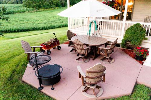 un patio con mesa, sillas y sombrilla en Summer Getaway with BBQ Grill, Outdoor Patio, & near Root River Bike Trail & Niagara Cave, 