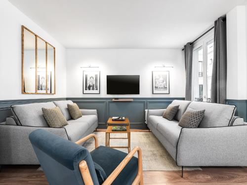 un salon avec deux canapés et une télévision dans l'établissement LivinParis - Luxury 2 Bedrooms Opera VI, à Paris