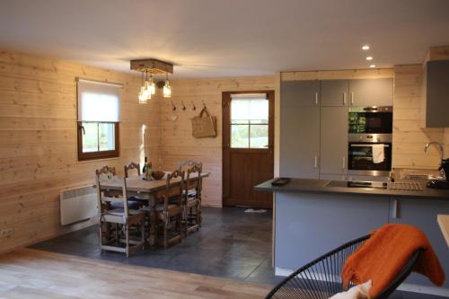 eine Küche mit einem Tisch und Stühlen im Zimmer in der Unterkunft le nid des Mésanges in Büllingen