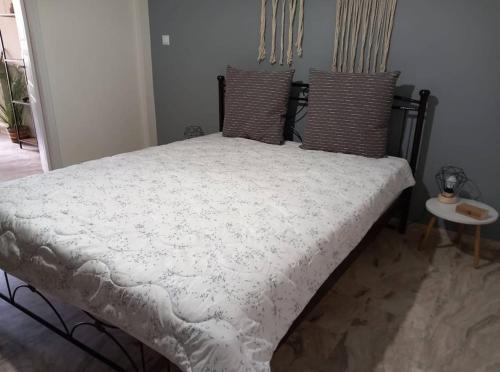 a bed with a white comforter and two pillows at "Orpheus" - Kalamata Centre in Kalamata