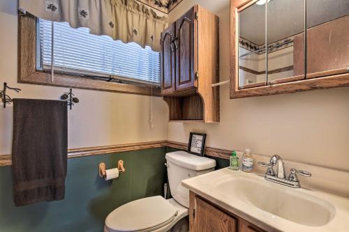 a bathroom with a toilet and a sink at Serene Woodruff Cottage Lakefront Access! in Woodruff