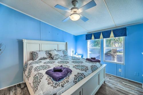 a blue bedroom with a bed and a ceiling fan at Atlantic Beach Home with Decks and Fire Pit in Atlantic Beach