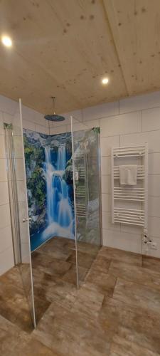 a bathroom with a shower and a mural of a waterfall at Haus Wibmer Martin in Matrei in Osttirol