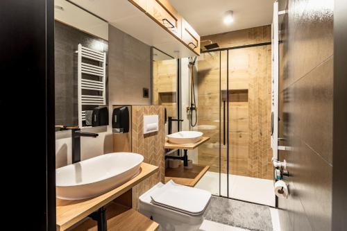 a bathroom with two sinks and a toilet and a shower at ZAKOHOME- Apartamenty Sabały in Zakopane