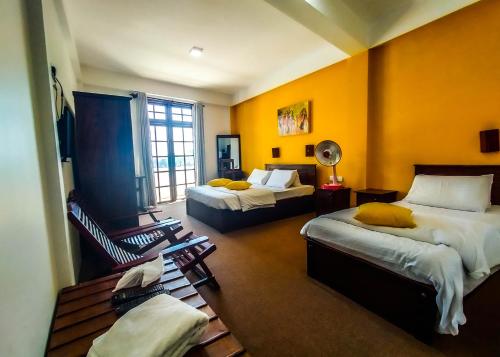 a hotel room with two beds and a window at MANUDI Glenfallsedge Rest in Nuwara Eliya