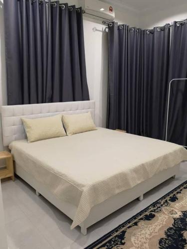 a large bed in a room with black curtains at Inap Singgah Homestay in Kota Bharu
