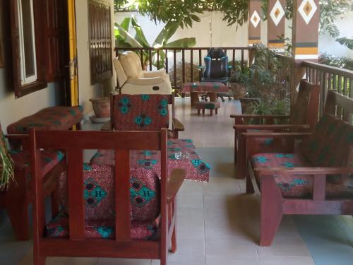 a room with chairs and tables and a balcony at Hotel Casa Sinkinling Gambia in Sere Kunda