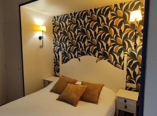 a bedroom with a white bed with a black and white wall at Le Pavillon Saint-Martin in Souillac