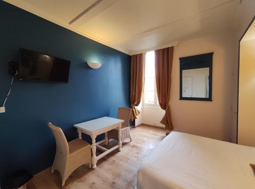 um quarto de hotel com uma mesa, uma cama e uma secretária em Le Pavillon Saint-Martin em Souillac