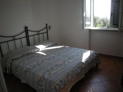 1 dormitorio con 1 cama con manta y ventana en Agriturismo Tendapiccola, en Ceriale
