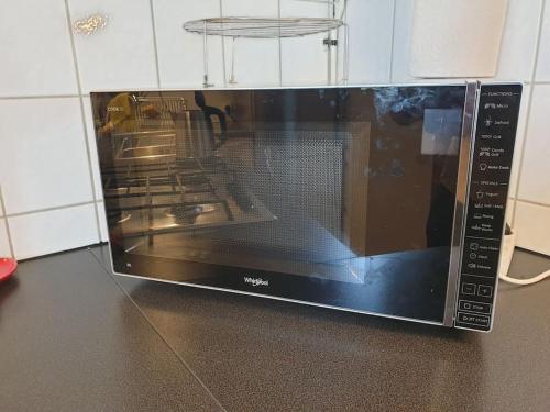 a microwave oven sitting on a kitchen counter at Audun-Le-Tiche - Appartements 3 chambres in Audun-le-Tiche