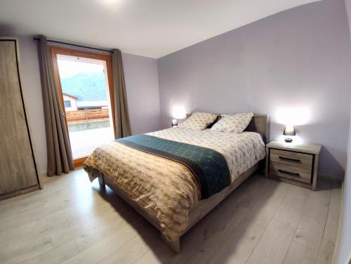 ein Schlafzimmer mit einem Bett und einem großen Fenster in der Unterkunft Les Randogodilleurs à 2kms des pistes et 350m du Théatre du Peuple ! in Bussang