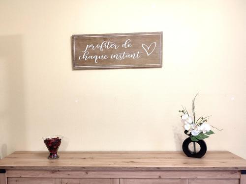 a wooden table with a sign on a wall at Les Randogodilleurs avec Jacuzzi à 2kms des pistes et 350m du Théatre du Peuple ! in Bussang