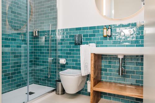 a blue tiled bathroom with a toilet and a sink at Ocean Porto - Beach House in Matosinhos