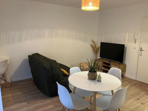 - un salon avec une table et un canapé dans l'établissement Studio cosy 12 min Arc de Triomphe, à Rueil-Malmaison