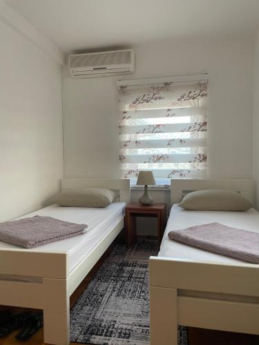 two twin beds in a room with a wall mural at Villa For You in Mostar