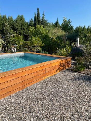 a swimming pool with a wooden fence around it at Nid de rêves jacuzzi en Provence in Châteaurenard