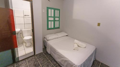 a small room with a bed and a toilet at Casa Karé - ITACARÉ in Itacaré