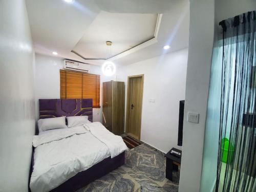 a bedroom with a large bed in a room at Dinero Ruby - Studio Apartment in Lagos