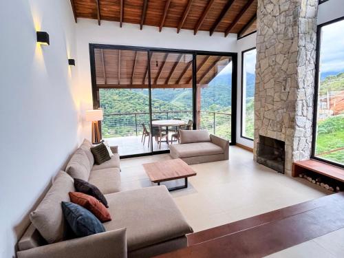 sala de estar con sofá y chimenea en MORADA DOS IPÊS, en Teresópolis