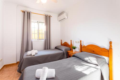 a bedroom with two beds and a window at Sun, Relax, Climatized Pool & Steps to the Beach by Mellow in Vélez-Málaga