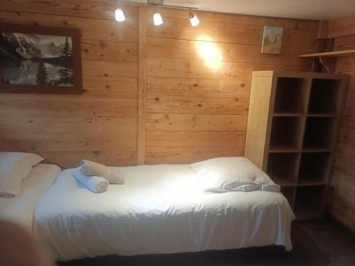 1 dormitorio con 2 camas en una pared de madera en Three Bedroomed Chalet Apartment, en Chamonix-Mont-Blanc